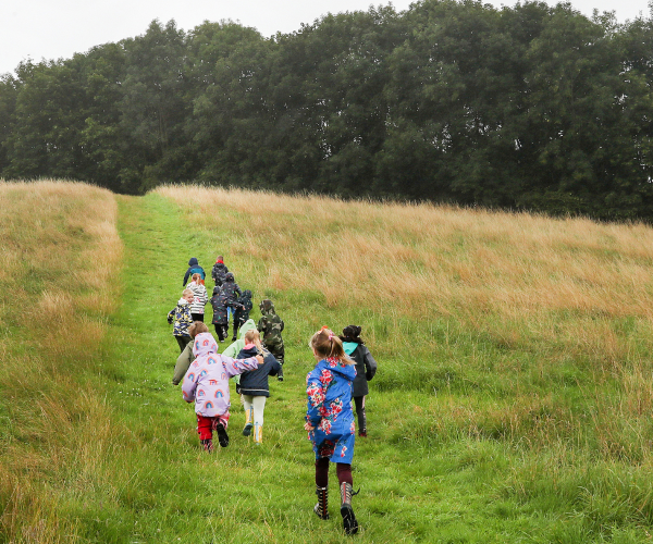 A group of children running up the hill at Middle Spernal.
