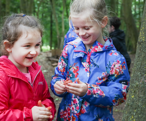 A couple of children laughing whilst playing in the woods